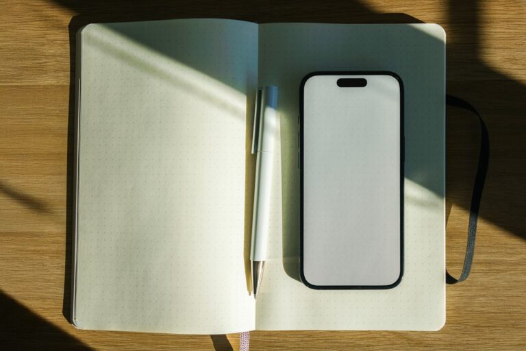 ノートとスマートフォンを使って写真や記録を整理するイメージ。Photo by Jakub Żerdzicki on Unsplash