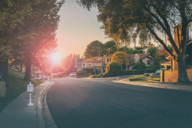 明るい地域の通りを歩く暮らしの風景。Photo by Nikola Knezevic on Unsplash
